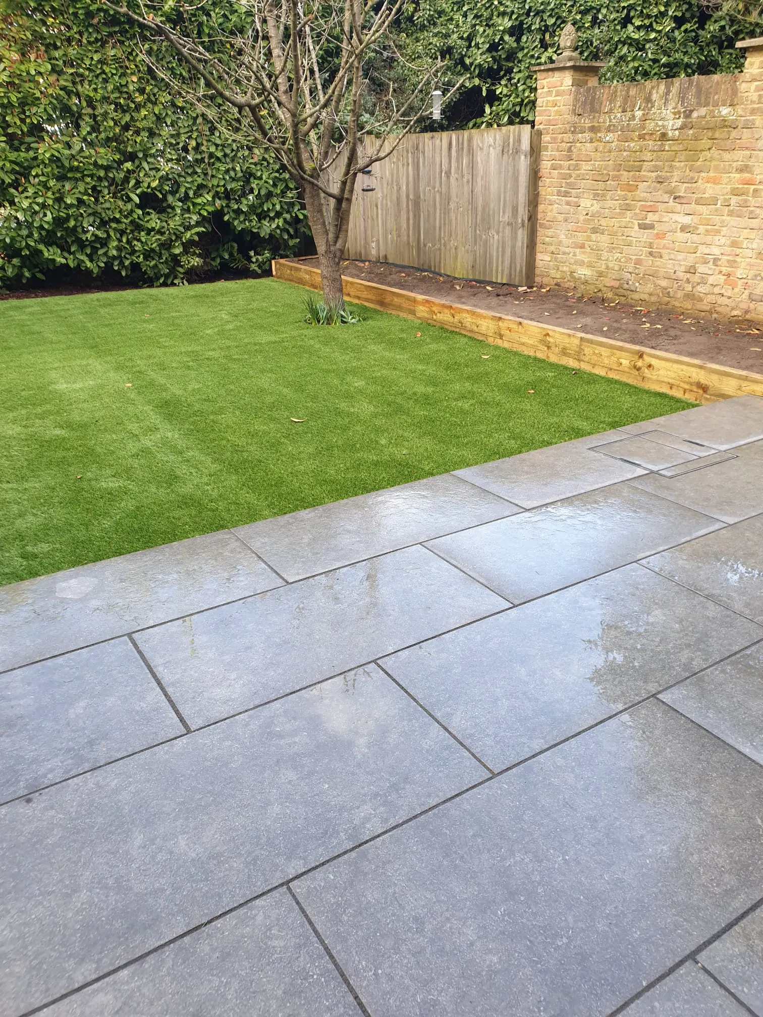 Large grey patio area with green 